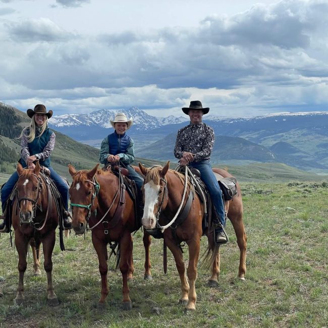 Family riding horses together on a scenic mountain trail during a horseback riding adventure at Rusty Spurr Ranch in Colorado.