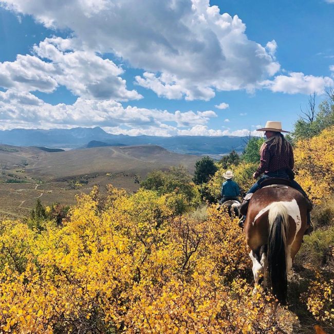 Parents and kids riding horses together on a family-friendly trail at Rusty Spurr Ranch in Colorado.