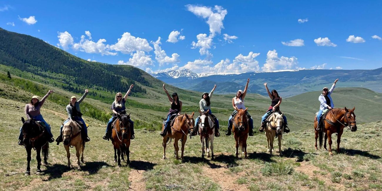 group of women on a horseback trail ride in colorado