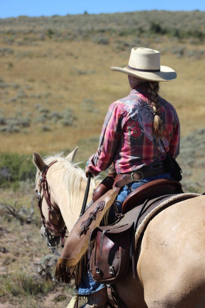 Rider holding reins correctly while navigating a scenic trail at Rusty Spurr Ranch